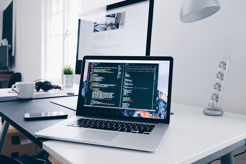 Desk setup with laptop and monitor during website development
