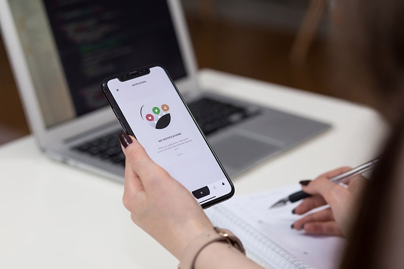 Woman holding phone during quality assurance and testing of site
